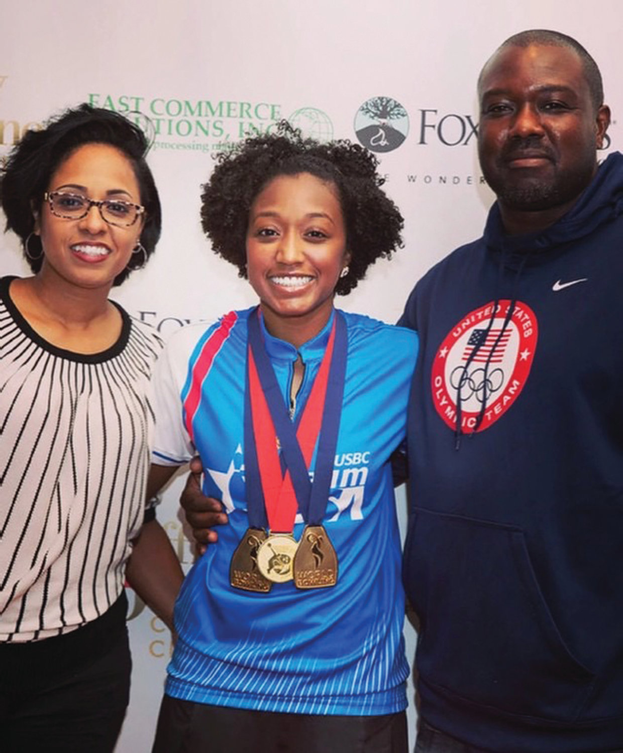 GOING FOR GOLD: Gazmine Mason shows off her gold medals while sharing a moment with her mother, Danielle Daley-Mason, and father, George Mason.